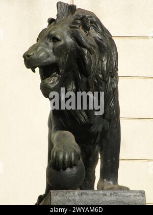 Scultura di leone in bronzo con zampa sulla sfera Foto Stock