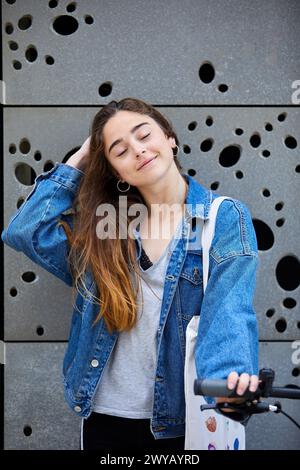 Giovane ragazza con bicicletta, esterni del Museo di San Telmo, Donostia, San Sebastian, Gipuzkoa, Paesi Baschi, Spagna. Foto Stock