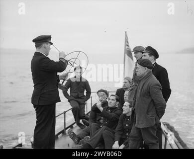 YACHT DIDATTICO MOBILE DEMS. 23 FEBBRAIO 1942, A BORDO DELLA MY MELITA, GOUROCK BAY. IL LANCIO MOTORISTICO È IL PRIMO LANCIO ISTRUTTIVO AD ESSERE UTILIZZATO PER L'EQUIPAGGIAMENTO DIFENSIVO DELLE NAVI MERCANTILI NEL REGNO UNITO. EFFETTUA VIAGGI GIORNALIERI VERSO GLI ANCORAGGI PER TENERE I MARINAI MERCANTILI INFORMATI E ISTRUITI SUGLI ULTIMI MIGLIORAMENTI PER LA DIFESA DELLE LORO NAVI. - Una classe di marinai mercantili che si sottopongono a un'istruzione a bordo del Motor Launch. , Foto Stock