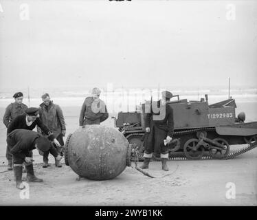 GLI SQUADRONI NAVALI DI RECUPERO E SMALTIMENTO DELLE MINE IN SCOZIA, 1939-1945 - i membri della Mine Recovery and Disposal Squad esaminano una mina navale sulla spiaggia di Tayport prima della sua rimozione con l'aiuto di una portaerei Bren gestita da truppe del 1° corpo polacco, 25 novembre 1941. , Esercito polacco, forze armate polacche in Occidente, 1° corpo, Royal Navy, classe corazzata, Canopus, squadra di recupero e smaltimento miniere Foto Stock