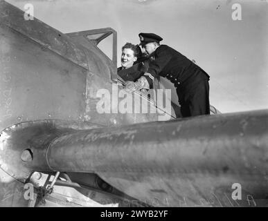 BRACCIO AEREO DELLA FLOTTA. 7 GENNAIO 1942, A BORDO DELLA HMS VICTORIOUS. PILOTI DI CACCIA E LE LORO MACCHINE. - Lieut (A) H B Happer, RNVR, ufficiale tecnico aeronautico, parlare con il pilota, Sub Lieut (A) P R J Gilbert, prima del riscaldamento. , Foto Stock