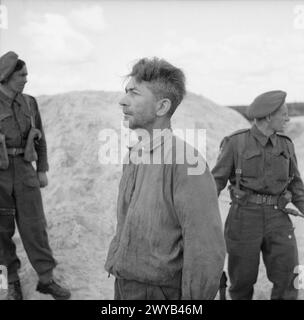 LA LIBERAZIONE DEL CAMPO DI CONCENTRAMENTO DI BERGEN-BELSEN, APRILE 1945 - il dottor Klein, un medico delle SS, che ha commesso la morte di migliaia di uomini, donne e bambini. In alcuni casi sperimentava sulle sue vittime iniettandole benzina in modo da indurire le arterie. Immagini: Il dottor Klein parla a nome del furgone del Movietone News davanti alla tomba in cui sono sepolte alcune delle sue vittime. , Foto Stock