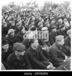 Gli sfollati in un campo russo ascoltano musica mentre sono sotto la supervisione del personale dell'esercito britannico durante la seconda guerra mondiale Foto Stock