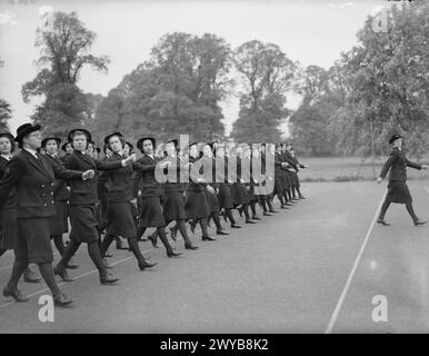 SUA MAESTÀ LA REGINA ISPEZIONA WRENS. 11 MAGGIO 1942, DEDWORTH MANOR, WINDSOR. LA REGINA ISPEZIONÒ WRENS DEL NAVAL PAY OFFICE. - Il WRNS sta marciando davanti alla Regina durante l'ispezione. I membri del Women's Royal Naval Service (WRNS) erano conosciuti colloquialmente come Wrens. I Wrens di Dedworth Manor facevano parte del complemento di uno stabilimento costiero della Royal Navy, chiamato HMS President III Lo stabilimento era responsabile della paga, dei conti e dell'amministrazione del personale che prestava servizio nelle navi mercantili difensive (DEMS). , Foto Stock