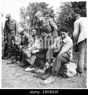 LAVORO CIVILE IN NORMANDIA - didascalia originale in tempo di guerra: Seduti su un albero, gli uomini provano i loro nuovi stivali. Negativo fotografico, British Army, 21st Army Group Foto Stock