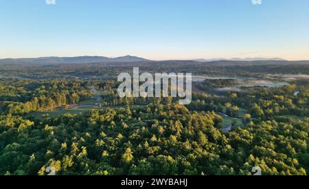 vista aerea delle lontane montagne nebbiose di catskills all'alba (ora d'oro, tramonto) con nebbia tra gli alberi in una giornata limpida con cielo blu Foto Stock