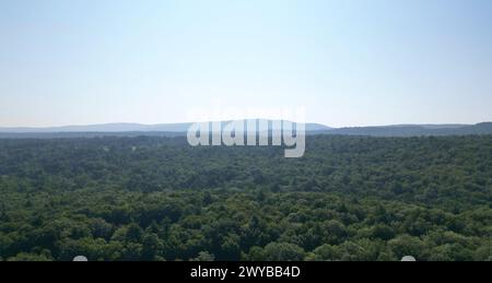 vista aerea delle lontane montagne nebbiose di catskills all'alba (ora d'oro, tramonto) con nebbia tra gli alberi in una giornata limpida con cielo blu Foto Stock