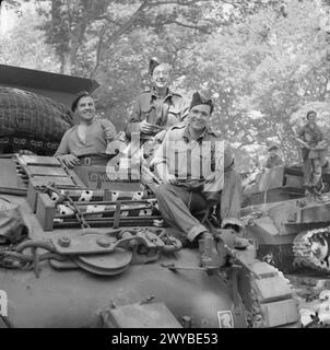 I ROYAL HUSSARS 13TH/18TH SI PREPARANO ALL'AZIONE - didascalia originale in tempo di guerra: The Crew of the Armour Recovery Vehicle [uno Sherman modificato] che va in prima marea. Tutti i gallesi, hanno chiamato il loro veicolo Cymru-am-Byth [Galles per sempre] e sperano che sia uno spettacolo gradito a tutti i gallesi dall'altra parte che lo vedono. Sono il Trooper T.G. Blackmore [Devon], il caporale W. Attew [Londra] e il Craftsman N.Leworthy [Cardiff]. , Foto Stock