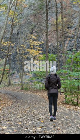 Donna che cammina su un sentiero escursionistico nel Taughannock Falls State Park (lago cayuga vicino a ithaca, a nord di New york) in autunno con fogliame autunnale (lascia changi Foto Stock