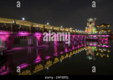 Una foto a lunga esposizione di un ponte del tempio Zuoying Yuandi decorato in modo luminoso e dei suoi riflessi sullo stagno del Loto Zuoying di notte Foto Stock