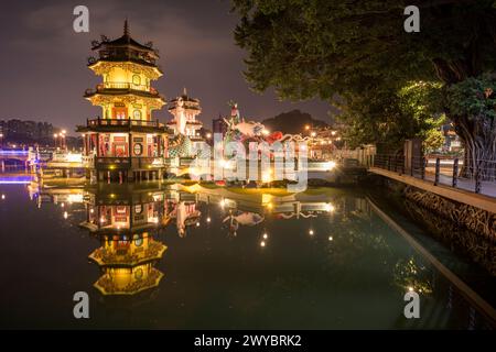 Un incantevole paesaggio notturno che mostra le pagode del drago e della tigre e un ponte, riflesso in un lago fermo Foto Stock