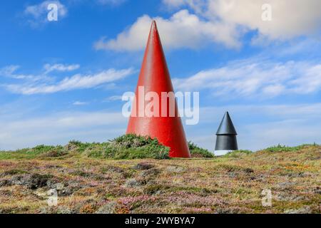 Una coppia di a forma di cono i marcatori di giorno, la navigazione Runnelstone marcatori, in linea con la boa Runnelstone, Testa Gwennap, Cornwall, Regno Unito Foto Stock