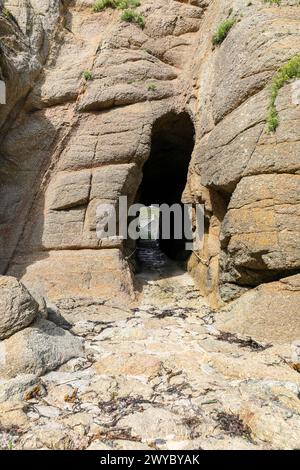 Uno spazio tra le rocce o un arco di roccia o un tunnel a Porthgwarra, Cornovaglia, Inghilterra sud-occidentale, Regno Unito Foto Stock