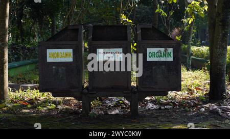 Un bidone arrugginito in un parco suddiviso in tre categorie di rifiuti: Rifiuti inorganici, rifiuti B3 e rifiuti organici Foto Stock