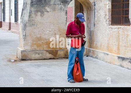 Un cubano che scrive qualcosa su un piccolo quaderno a l'Avana, Cuba Foto Stock