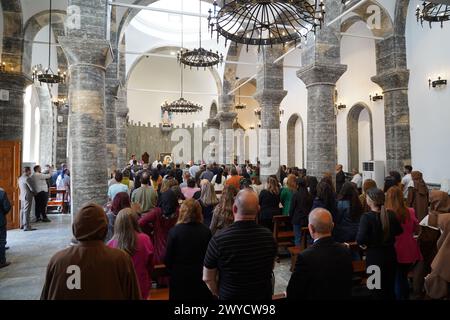 Mosul, Iraq. 5 aprile 2024. I fedeli cristiani iracheni partecipano alla messa presso la Chiesa cattolica caldea di 80 anni di um al-Mauna, "nostra Signora del Perpetuo aiuto”, a Mosul, nel nord dell'Iraq. Con allegri applausi e ulululazioni, i cristiani iracheni hanno celebrato il restauro della chiesa con una cerimonia di canonizzazione e dedica il 5 aprile, anni dopo che l'ISIS l'ha trasformata in un ufficio di polizia religiosa e in un centro di autobomba. (Foto di Ismael Adnan/SOPA Images/Sipa USA) credito: SIPA USA/Alamy Live News Foto Stock