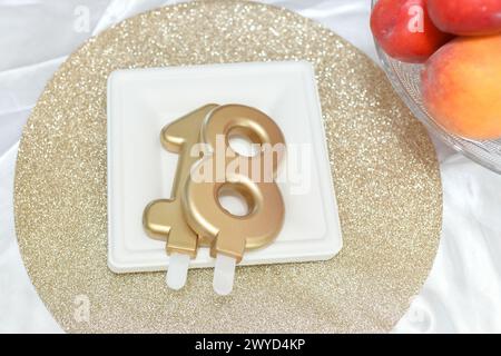 Candele numero diciotto su un piatto di torta Foto Stock