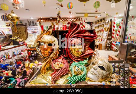 Tipiche maschere colorate di carnevale per souvenir turistici in mostra in una vetrina a San Marco, Venezia, Italia Foto Stock