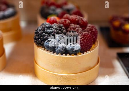 Dolce dolce italiano dolce pasticceria e torte con panna e frutta in mostra nella panetteria artigianale di Milano, in Italia, da vicino Foto Stock