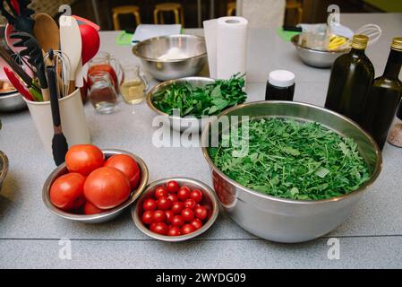 Ingredienti freschi preparati per uso culinario in cucina. Una varietà di ingredienti freschi, tra cui pomodori e verdure, pronti per la cottura in cucina Foto Stock