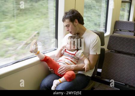 Padre (35 anni) e nostra figlia di 2 anni) in viaggio in tram. Foto Stock