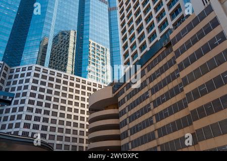 Parcheggi a più piani alla base dei grattacieli, vista sulla città. Facciata grattacieli con finestre in plesso Foto Stock