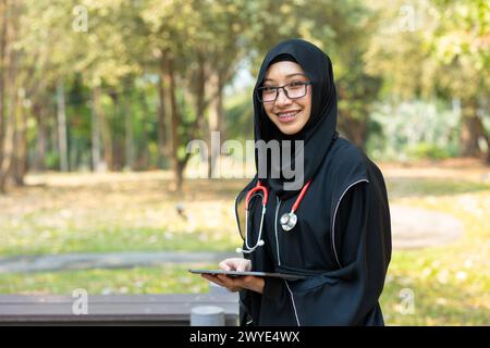 Adolescente saudita con stetoscopio per lo stile di vita delle donne arabe in una scuola di medicina universitaria campus natura background. Foto Stock