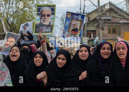 Le donne musulmane del Kashmir hanno dei cartelli mentre cantano slogan contro Israele e l'America durante una protesta contro le operazioni militari israeliane a Gaza, nel Magam del Kashmir centrale, a circa 25 km da Srinagar. Decine di musulmani del Kashmir hanno portato cartelli e bandiere palestinesi durante una manifestazione nel Magam centrale del Kashmir a circa 25 km da Srinagar, commemorando il giorno di al-Quds (Gerusalemme). La giornata di al-Quds è osservata a livello globale l'ultimo venerdì (Jumat-ul-Vida) del mese Santo del Ramadan per esprimere solidarietà e sostegno ai palestinesi. Foto Stock