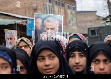 Srinagar, India. 5 aprile 2024. Le donne musulmane hanno dei cartelli mentre cantano slogan contro Israele e l'America durante una protesta contro le operazioni militari israeliane a Gaza. Decine di musulmani del Kashmir hanno portato cartelli e bandiere palestinesi durante una manifestazione nel Magam centrale del Kashmir a circa 25 km da Srinagar, commemorando il giorno di al-Quds (Gerusalemme). La giornata di al-Quds è osservata a livello globale l'ultimo venerdì (Jumat-ul-Vida) del mese Santo del Ramadan per esprimere solidarietà e sostegno ai palestinesi. Credito: SOPA Images Limited/Alamy Live News Foto Stock