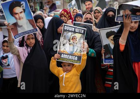 Srinagar, India. 5 aprile 2024. Le donne musulmane hanno dei cartelli mentre cantano slogan contro Israele e l'America durante una protesta contro le operazioni militari israeliane a Gaza. Decine di musulmani del Kashmir hanno portato cartelli e bandiere palestinesi durante una manifestazione nel Magam centrale del Kashmir a circa 25 km da Srinagar, commemorando il giorno di al-Quds (Gerusalemme). La giornata di al-Quds è osservata a livello globale l'ultimo venerdì (Jumat-ul-Vida) del mese Santo del Ramadan per esprimere solidarietà e sostegno ai palestinesi. Credito: SOPA Images Limited/Alamy Live News Foto Stock