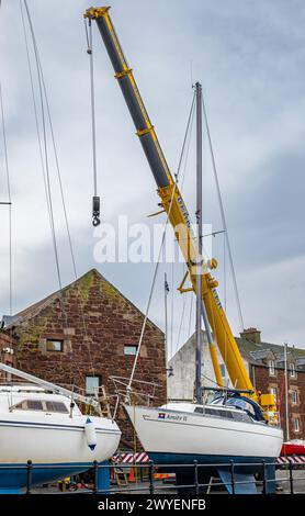 North Berwick Harbour, East Lothian, Scotland, UK, 6 aprile 2024. Yacht in acqua: L'evento annuale di organizzazione di una gru per trasportare oltre 20 barche a vela in acqua per la stagione estiva si svolge oggi. Crediti: Sally Anderson/Alamy Live News Foto Stock