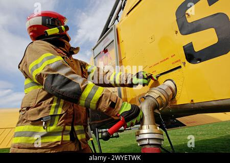 Ballenstedt, Germania. 6 aprile 2024. I vigili del fuoco riempiono il serbatoio di un piccolo aereo antincendio presso l'aeroporto di Ballenstedt. Il pilota dell'aereo polacco, progettato per aiutare a spegnere gli incendi boschivi dall'aria, è di stanza a Ballenstedt da aprile. Crediti: Matthias Bein/dpa/Alamy Live News Foto Stock