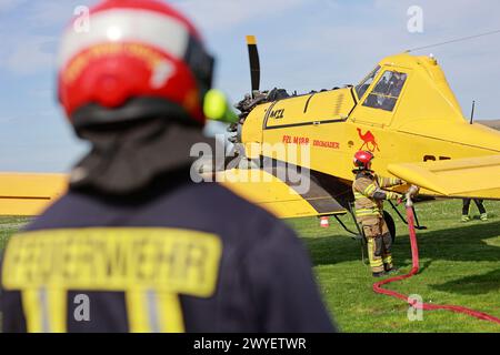 Ballenstedt, Germania. 6 aprile 2024. I vigili del fuoco riempiono il serbatoio di un piccolo aereo antincendio presso l'aeroporto di Ballenstedt. Il pilota dell'aereo polacco, progettato per aiutare a spegnere gli incendi boschivi dall'aria, è di stanza a Ballenstedt da aprile. Crediti: Matthias Bein/dpa/Alamy Live News Foto Stock