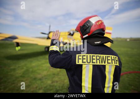 Ballenstedt, Germania. 6 aprile 2024. I vigili del fuoco riempiono il serbatoio di un piccolo aereo antincendio presso l'aeroporto di Ballenstedt. Il pilota dell'aereo polacco, progettato per aiutare a spegnere gli incendi boschivi dall'aria, è di stanza a Ballenstedt da aprile. Crediti: Matthias Bein/dpa/Alamy Live News Foto Stock