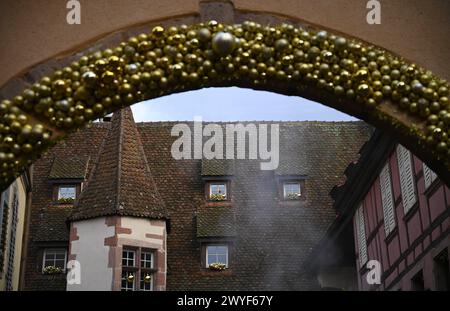Paesaggio urbano con vista panoramica di edifici antichi e festose decorazioni natalizie dorate a Riquewihr, Alsazia, Francia. Foto Stock