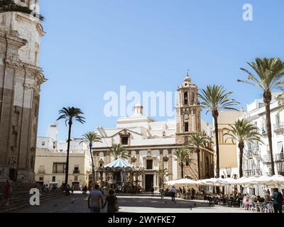 Cadice, Spagna - 12 settembre 2023 - Chiesa di Santiago in Plaza de la Catedral (Piazza della Cattedrale) con caffetterie sul lato destro, Cadice, Andal Foto Stock