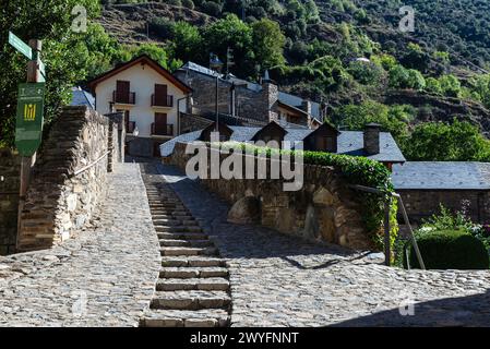 Case tipiche e il ponte romanico sul fiume Noguera Pallaresa del villaggio rustico di Esterri Aneu, Lleida, Catalogna, Spagna Foto Stock