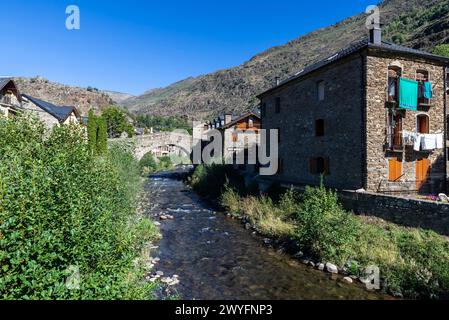 Case tipiche e il ponte romanico sul fiume Noguera Pallaresa del villaggio rustico di Esterri Aneu, Lleida, Catalogna, Spagna Foto Stock