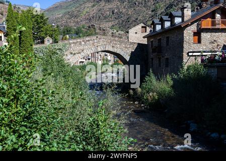 Case tipiche e il ponte romanico sul fiume Noguera Pallaresa del villaggio rustico di Esterri Aneu, Lleida, Catalogna, Spagna Foto Stock