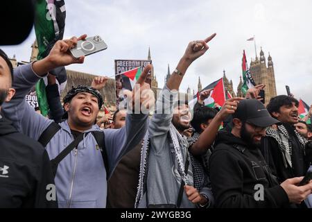 I manifestanti cantano slogan fuori dal Parlamento a Westminster durante la protesta al Quds Day organizzata dal Comitato per la giustizia per la Palestina. L'evento annuale si svolge a sostegno della Palestina e contro l'occupazione israeliana dei territori palestinesi. Foto Stock