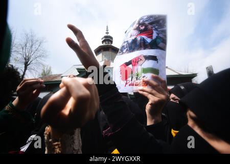 Le donne musulmane sciite kashmiri hanno striscioni e cartelli mentre cantano slogan contro Israele e gli Stati Uniti durante una protesta contro le operazioni militari israeliane a Gaza, il 5 aprile 2024, a Magam, a nord di Srinagar, Kashmir amministrato dagli indiani, India. Decine di musulmani sciiti del Kashmir portarono cartelli e bandiere palestinesi durante una marcia nel Magam del Kashmir centrale, commemorando il giorno di al-Quds (Gerusalemme). La giornata di al-Quds è osservata a livello globale l'ultimo venerdì (Jumat-ul-Vida) del mese Santo del Ramadan per esprimere solidarietà e sostegno ai palestinesi. (Foto di Mubashir Hassan/Pacific Press) Foto Stock