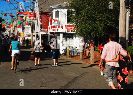 Una coppia cammina lungo Commercial Street, la principale strada commerciale di Provincetown, Cape Cod, in un giorno d'estate Foto Stock