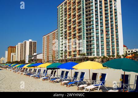 Sdraio e ombrelloni attendono gli amanti del sole durante le loro vacanze estive a Myrtle Beach, South Carolina Foto Stock