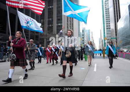 New York, Stati Uniti. 6 aprile 2024. Un partecipante alla parata marciò mentre sventolava la bandiera scozzese alla 26a parata annuale del Tartan Day di New York City sulla Sixth Avenue. La parata annuale che commemora la cultura scozzese, attira bagpiper, ballerini delle Highland, organizzazioni scozzesi-americane e festeggiamenti a Midtown Manhattan, New York City. Nel 1998, il Senato degli Stati Uniti istituì il 6 aprile come National Tartan Day "per riconoscere gli eccezionali risultati e contributi degli scozzesi americani agli Stati Uniti". Credito: SOPA Images Limited/Alamy Live News Foto Stock