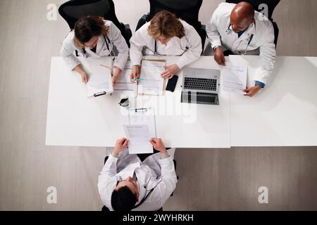 Giovane dottore seduto al colloquio di lavoro in ospedale Foto Stock