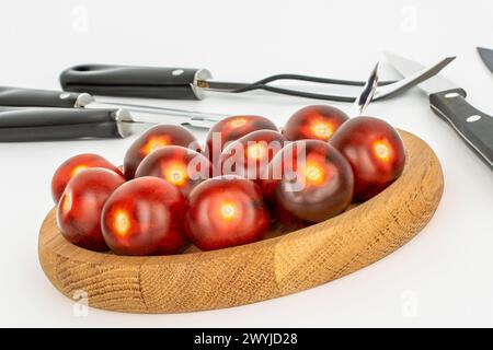 Diversi pomodori ciliegini neri maturi su un vassoio di legno, macro. Foto Stock