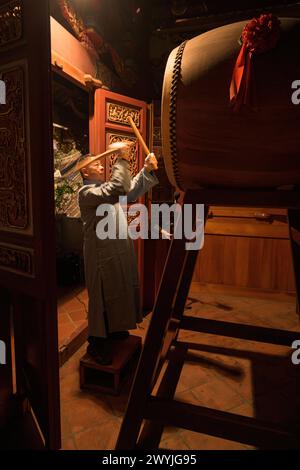 Uomo che suona il tamburo tradizionale durante la cerimonia di Capodanno al tempio di Dalongdong Baoan Foto Stock