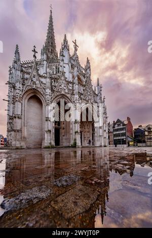 Francia, Senna-Marittima, Rouen, Place Barthélémy, riflesso della chiesa di Saint Maclou in una pozza di acqua piovana sui ciottoli della strada Foto Stock