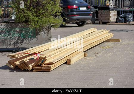 Materiale da costruzione in legno su asfalto in una strada cittadina Foto Stock