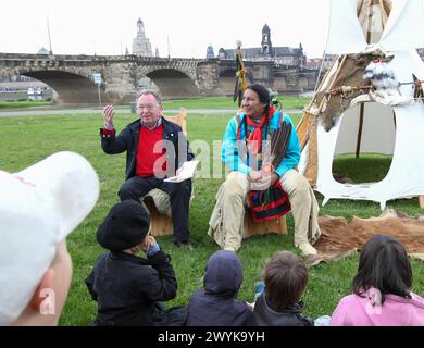 15.05.2012, Deutschland, Sachsen, Dresda, Augustusbrücke, Neustädter Elbseite, Elbwiesen, der Schauspieler und Schirmherr der Karl-May-Festspiele Radebeul Peter Sodann Roter Pullover und Murray Small Legs, Blackfoot-Indianer aus Kanada hellblaue Jacke, Lesen Kindergartenkindern zur Einstimmung auf die Karl-May-Festtage in Radebeul Geschichten vor ******* 15, 2012, Germania Augustusbrücke Neustädter Elbseite, Elbwiesen, l'attore e patrono del Karl May Festival Radebeul Peter Sodann maglione rosso e Murray zampe piccole, Blackfoot indiano dal Canada giacca azzurra , leggi tutto Foto Stock